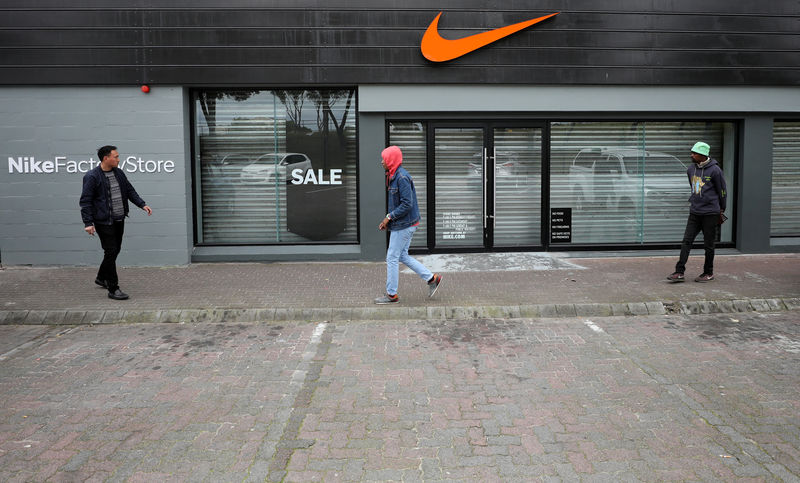 © Reuters. People walk past a closed Nike store in Cape Town