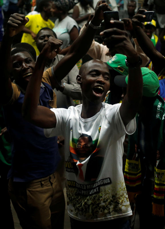 © Reuters. Supporters of President Emmerson Mnangagwa's ruling ZANU-PF party react to the results of a constitutional court hearing challenging his electoral victory in Harare