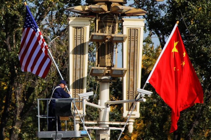 © Reuters. A worker places U.S. and China flags near the Forbidden City ahead of a visit by U.S. President Donald Trump to Beijing, in Beijing