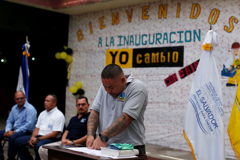 © Reuters. Un exmiembro de Barrio 18 estampa sus huellas digitales en un documento durante una ceremonia en la que el Gobierno salvadoreño aceptó su retiro oficial de esa pandilla en la prisión San Francisco Gotera