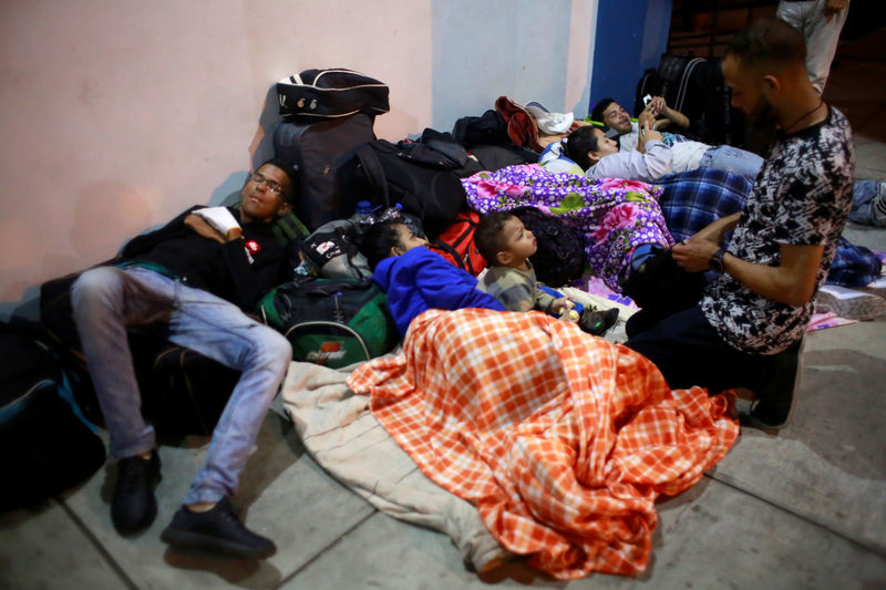 © Reuters. Inmigrantes venezolanos esperan en centro fronterizo de la localidad peruana de Tumbes, en la frontera con Ecuador