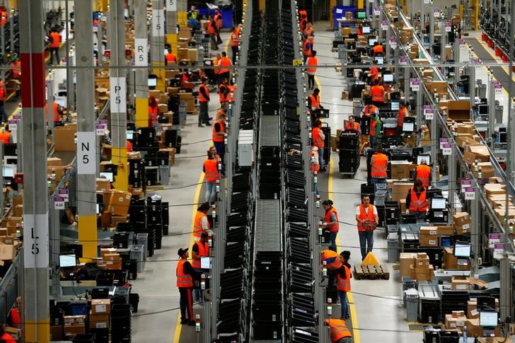 © Reuters. Employees handle packages in the new Amazon logistic center in Dortmund