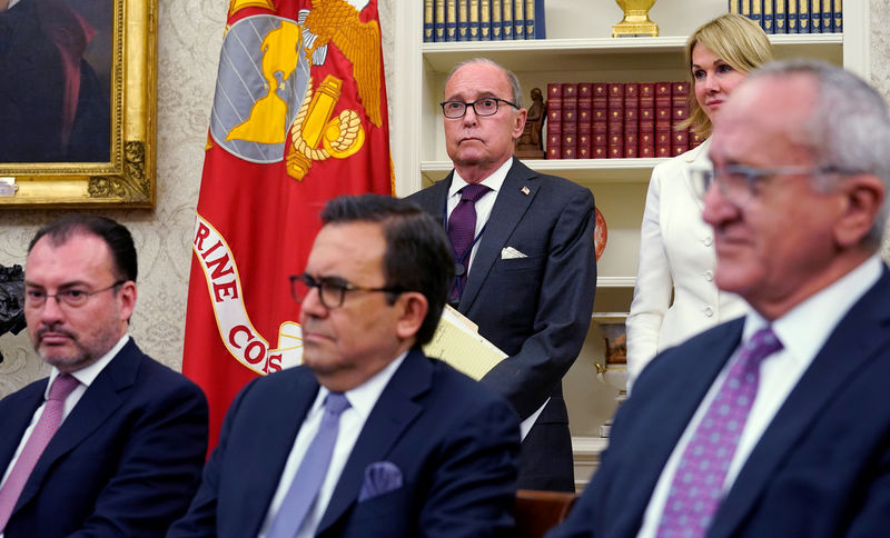 © Reuters. White House aides look on as Trump announces deal on NAFTA at the White House in Washington