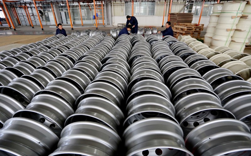 © Reuters. FILE PHOTO: Workers arrange steel rims for export at a wheel factory in Lianyungang