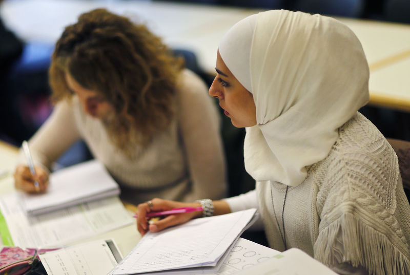 © Reuters. Migrants who worked as teachers in their home countries takes part in a programme to educate them for German schools at the University in Potsdam