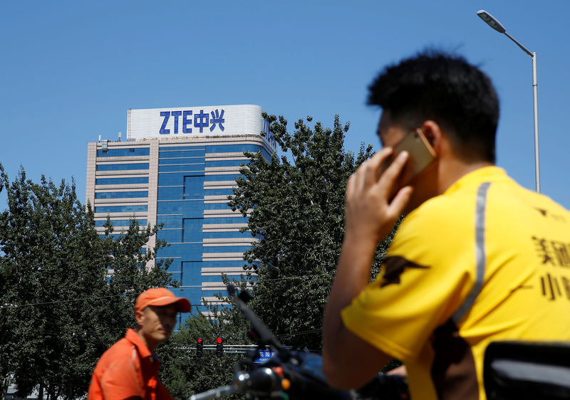 © Reuters. A delivery man uses a phone near a building of China's ZTE Corp in Beijing