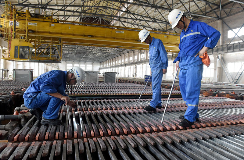 © Reuters. FILE PHOTO: Workers inspect the production of copper cathodes at a Jinlong Copper plant in Tongling