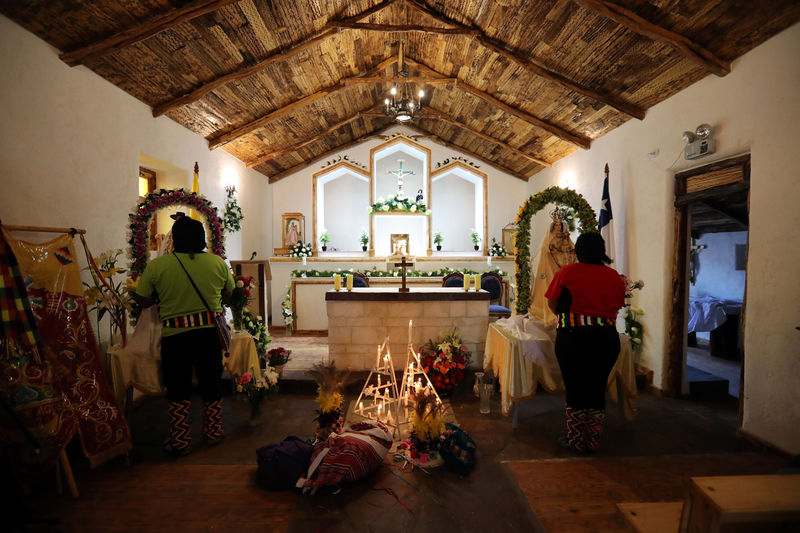 © Reuters. Locals pray inside a church during a religious holiday at Peine area at the Atacama Salt Flat in the Atacama Desert