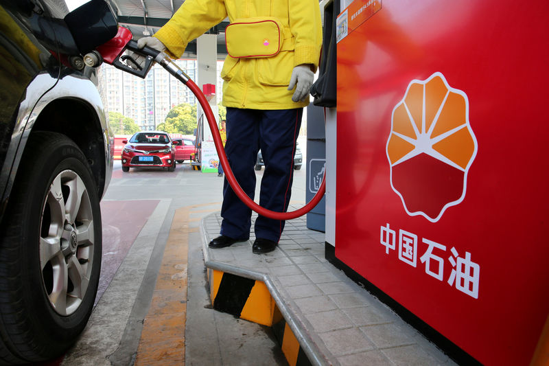 © Reuters. FILE PHOTO: A gas station attendant pumps fuel into a customer's car at PetroChina's petrol station in Nantong