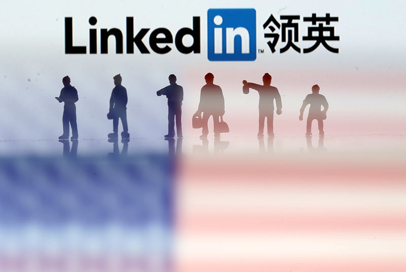 © Reuters. Small toy figures are seen between displayed U.S. flag and Linkedin logo in this illustration picture
