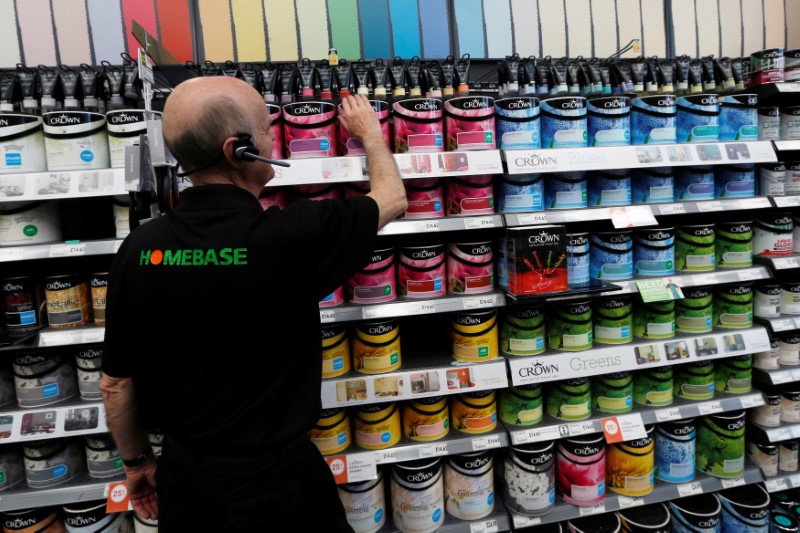 © Reuters. FILE PHOTO: A sales assistant tidies up a shelf of paint at a Homebase store in Aylesford