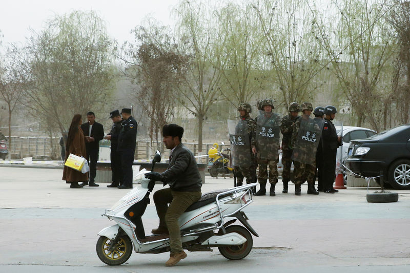 © Reuters. Agentes de polícia checam identidade de pessoas em rua de Kashgar, em Xinjiang