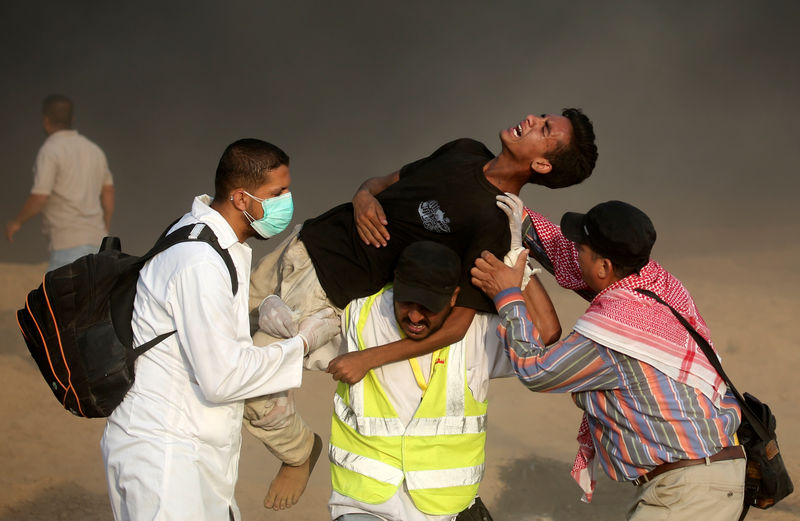 © Reuters. Médicos carregam palestino ferido durante protesto em Gaza