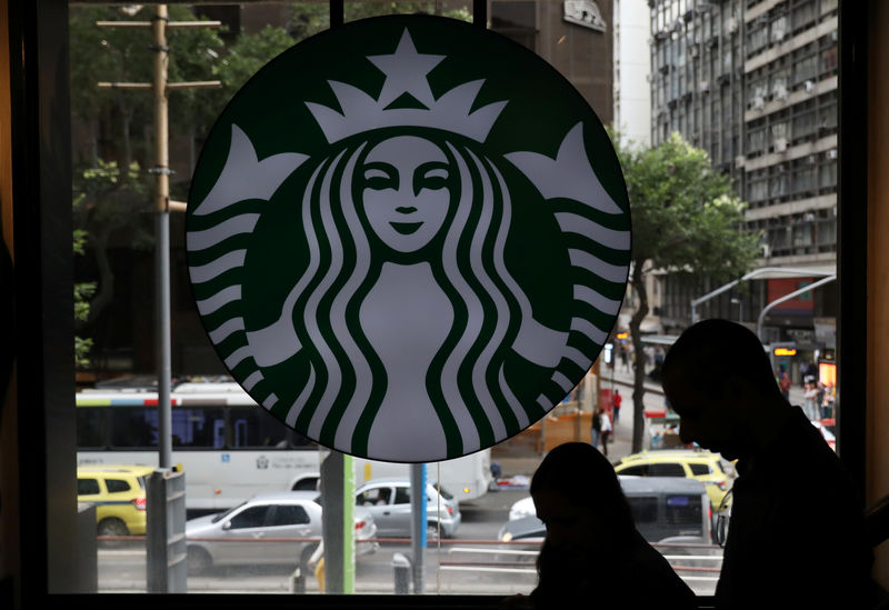 © Reuters. Customers pass by the logo of an American coffee company Starbucks inside a coffee shop in Rio de Janeiro