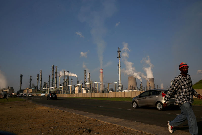 © Reuters. FILE PHOTO: A man walks past South African petrochemical company Sasol's synthetic fuel plant in Secunda