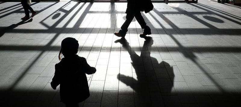 © Reuters. FILE PHOTO: People's shadows are seen as shoppers are silhouetted in the bright sunshine at the Westfield shopping centre, Stratford, London