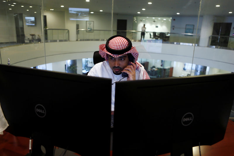 © Reuters. A Saudi trader observes the stock market on monitors at Falcom stock exchange agency in Riyadh