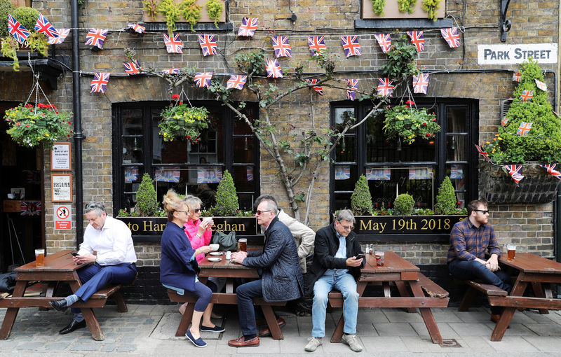 © Reuters. Customers sit under Union Flag bunting outside a pub decorated ahead of Prince Harry and Meghan Markle's wedding, in Windsor