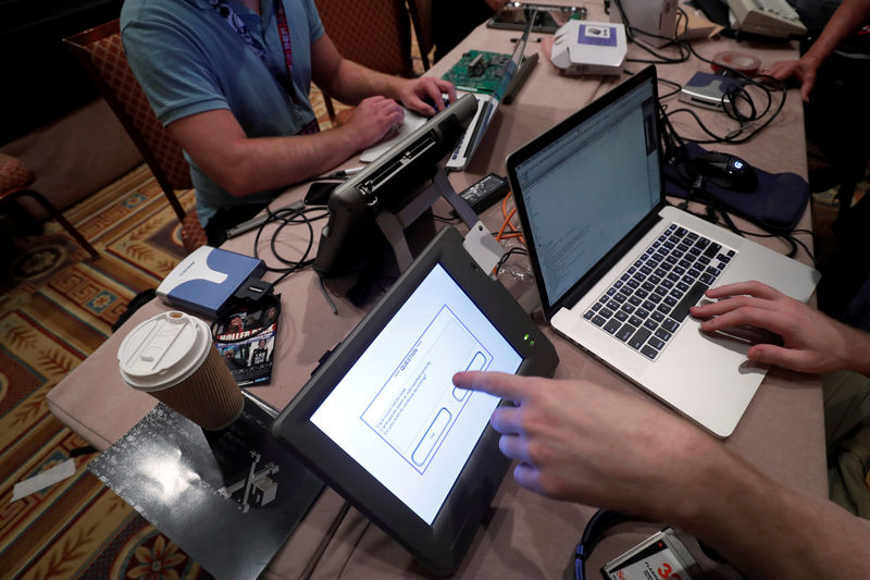 © Reuters. FILE PHOTO: Hackers try to access and alter data from an electronic poll books in a Voting Machine Hacking Village during the Def Con hacker convention in Las Vegas