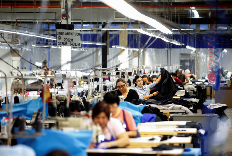 © Reuters. FILE PHOTO - Workers make jackets at the Canada Goose factory in Toronto