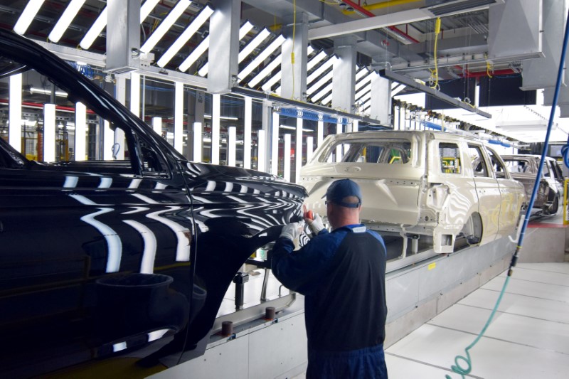 © Reuters. FILE PHOTO: A Ford worker inspects paint work on the body of a Ford Expedition SUV at Ford's Kentucky Truck Plant in Louisville