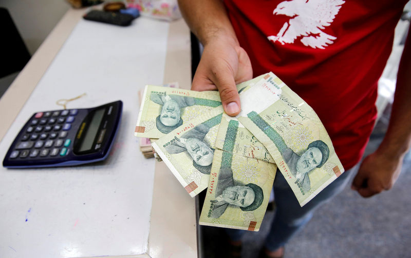 © Reuters. FILE PHOTO: A vendor inspects Iranian rials at a currency exchange shop in Baghdad