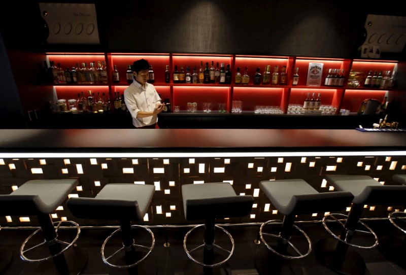 © Reuters. Waiter works in a bar at First Cabin hotel, which was converted from an old office building, in Tokyo