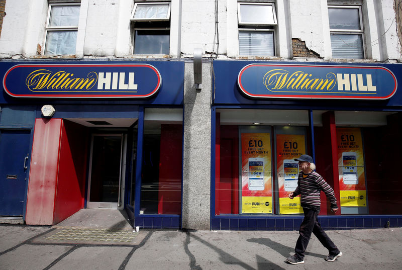 © Reuters. A pedestrian walks past a William Hill betting shop in London