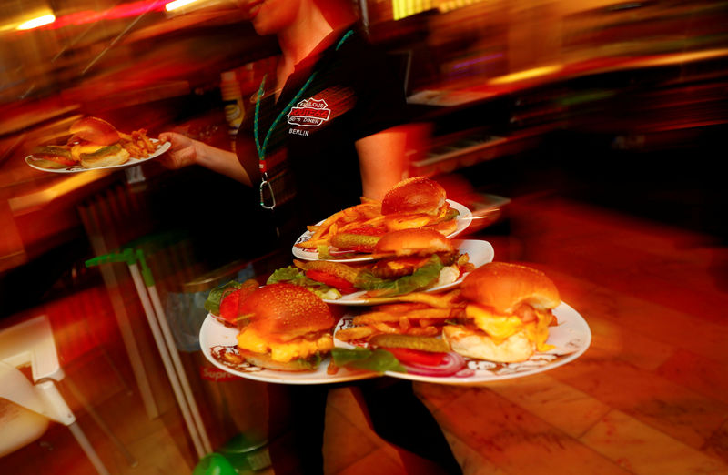 © Reuters. FILE PHOTO: A waitress serves hamburgers at "Route 66 Diner", which offers American diner food, in Berlin