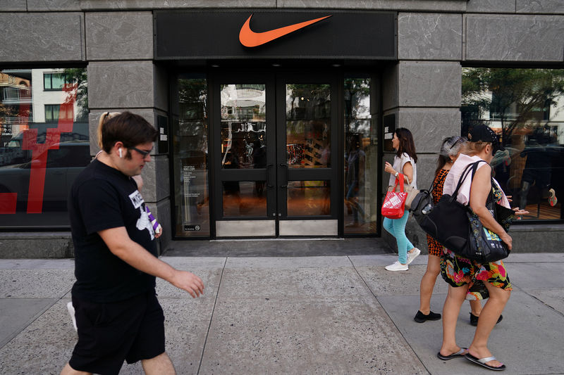 © Reuters. People walk past a Nike store in New York City,