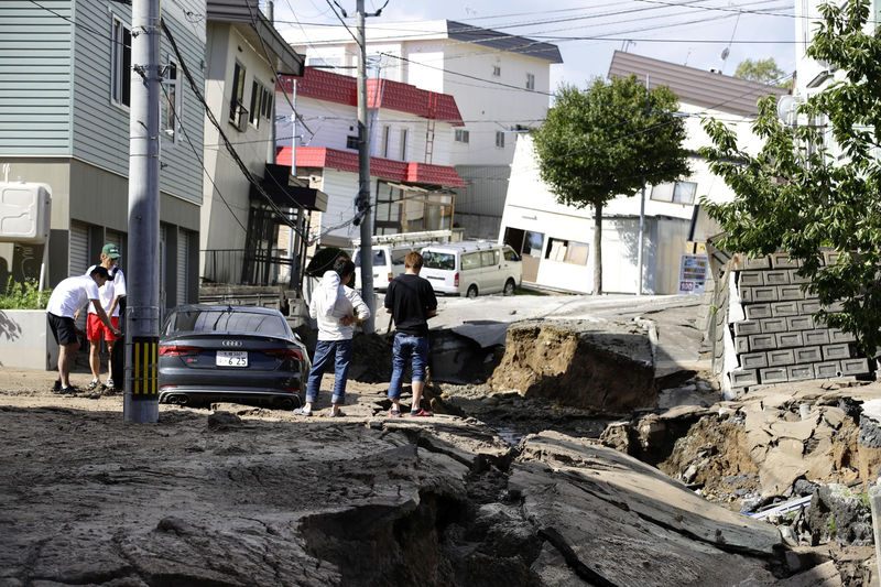 © Reuters. People look at an area damaged by an earthquake in Sapporo