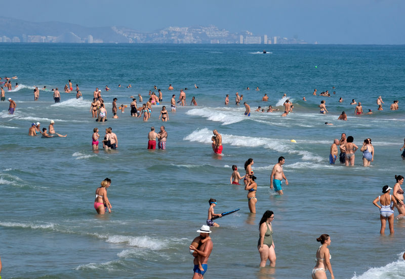 © Reuters. Beachgoers swim at the eastern coast to enjoy the last days of the summer season in Gandia near Valencia