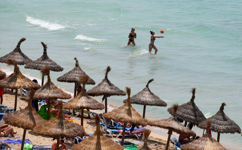 © Reuters. Tourists sunbathe in El Arenal beach in the island of Mallorca