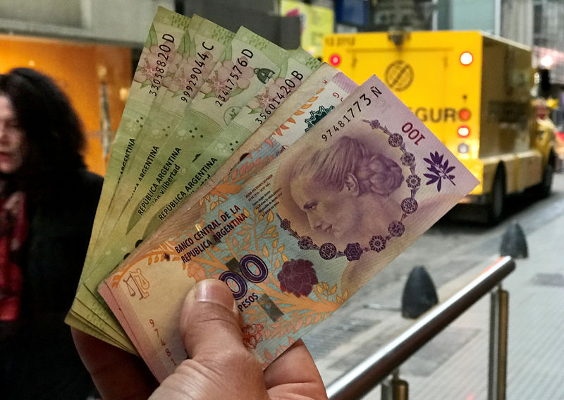 © Reuters. Pessoa segura notas de peso argentino em Buenos Aires, Argentina