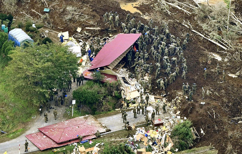 © Reuters. Members of JSDF search for survivors from a house damaged by a landslide caused by an earthquake in Atsuma town