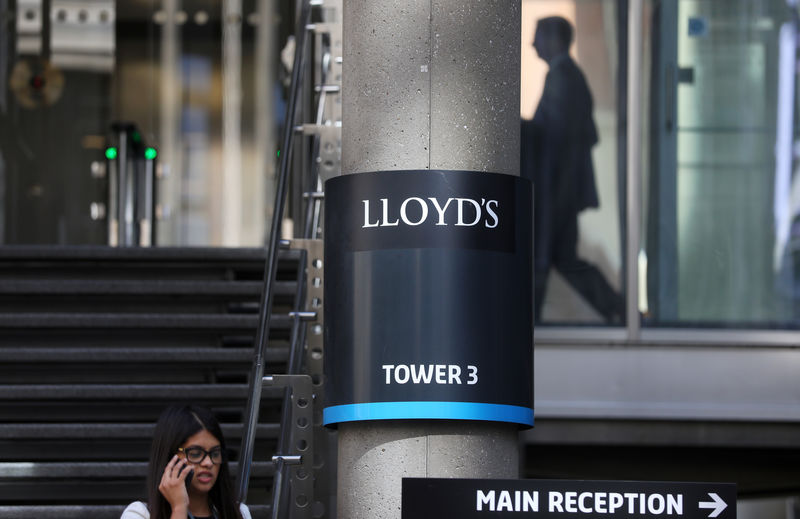 © Reuters. A woman speaks on her mobile phone as she walks out of Lloyds of London's headquarters in the City of London