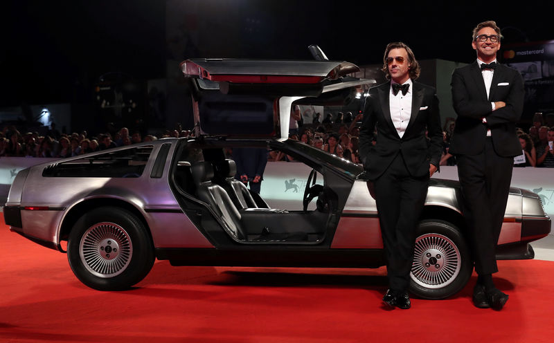 © Reuters. Los actores Jason Sudeikis y Lee Pace posan junto a un auto DeLorean en la alfombra roja en el Festival de Cine de Venecia