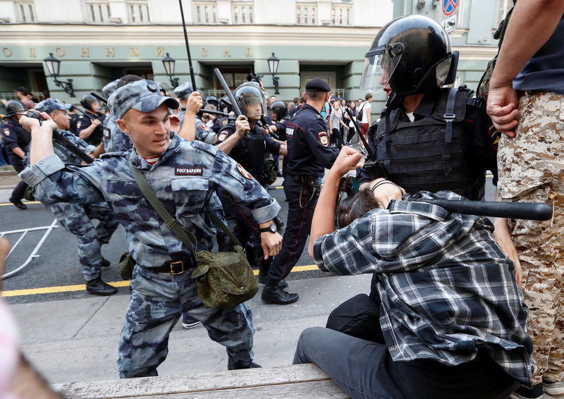 © Reuters. A serviceman of the Russian National Guard beats a protester during a rally against planned increases to the nationwide pension age in Moscow