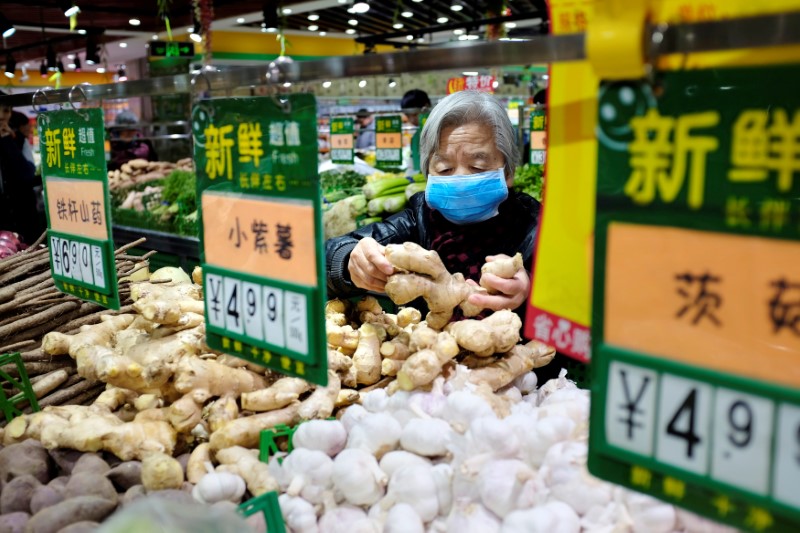© Reuters. A resident selects ginger at a supermarket in Beijing