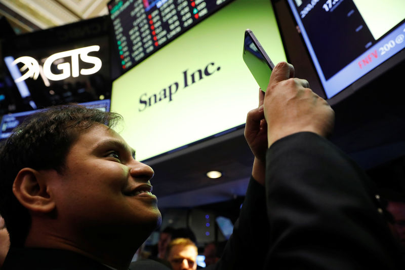 © Reuters. FILE PHOTO - Snap Inc. chief strategy officer, Imran Khan, takes a photograph on the floor of the New York Stock Exchange (NYSE) while waiting for Snap Inc. to post their IPO in New York