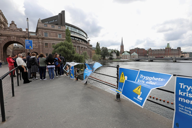 © Reuters. People stand next to election posters near the Swedish parliament in Stockholm