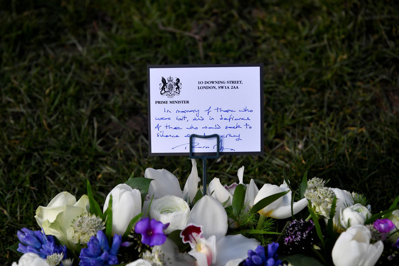 © Reuters. FILE PHOTO: A hand-written message by Britain's Prime Minister Theresa May left with a wreath of flowers on Parliament Square in Westminster on the anniversary of the Westminster Bridge attack in London