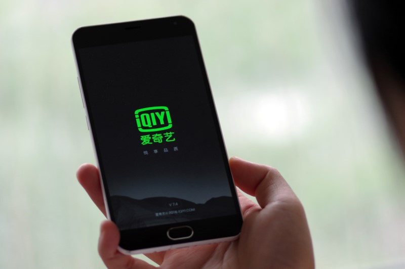 © Reuters. Uma pessoa segura um telefone com o serviço de streaming de vídeo iQiyi da Baidu em Jinan, província de Shandong, China