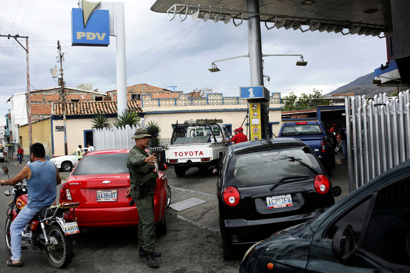 © Reuters. Soldado venezuelano controla o tráfego enquanto carros fazem fila para abastecer em posto de combustível em San Antonio