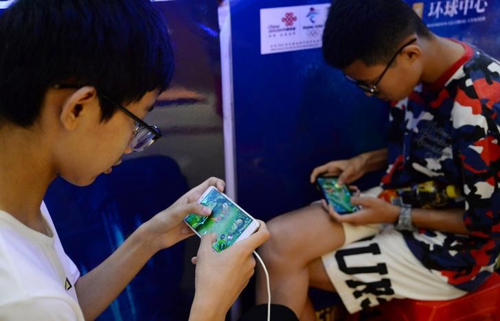 © Reuters. Jovens jogam videogame em celulares em Handan, China