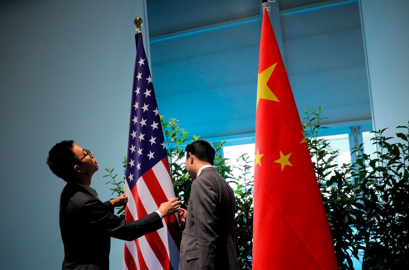 © Reuters. FILE PHOTO: Chinese officials prepare the flags for the China-U.S. bilateral meeting at the G20 leaders summit in Hamburg