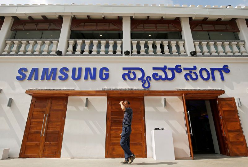 © Reuters. Homem passam em frente à loja recém inagurada da Samsung em Bengaluru, na Índia