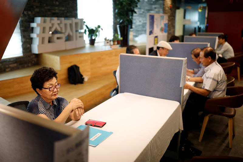 © Reuters. A woman waits for job seekers, at a local job fair in Seoul