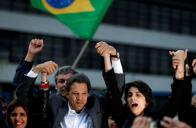 © Reuters. Candidato do PT à Presidência, Fernando Haddad, dá as mãos com candidata a vice, Manuela D'Ávila em frente à sede da Polícia Federal em Curitiba