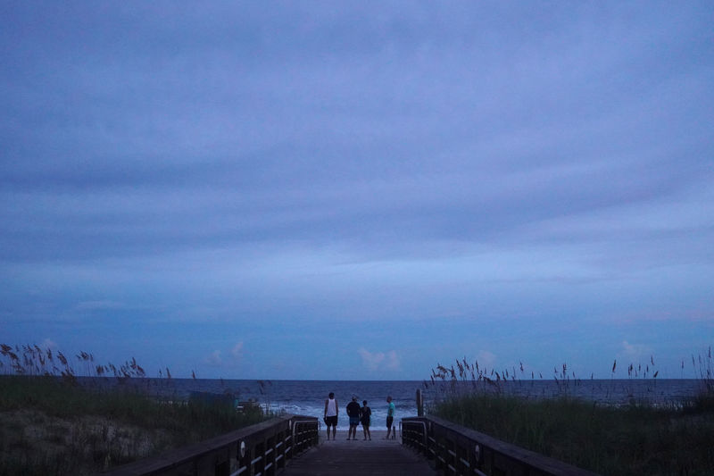 © Reuters. La gente se para en la playa y observa el oleaje antes de que el huracán Florence llegue a la costa en Carolina Beach